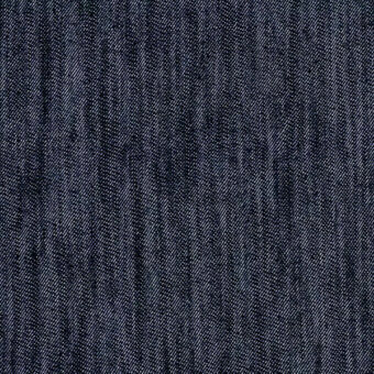 Dark indigo denim fabric texture with a tight, diagonal rib weave and subtle heathered tonal variations, suggesting durability.